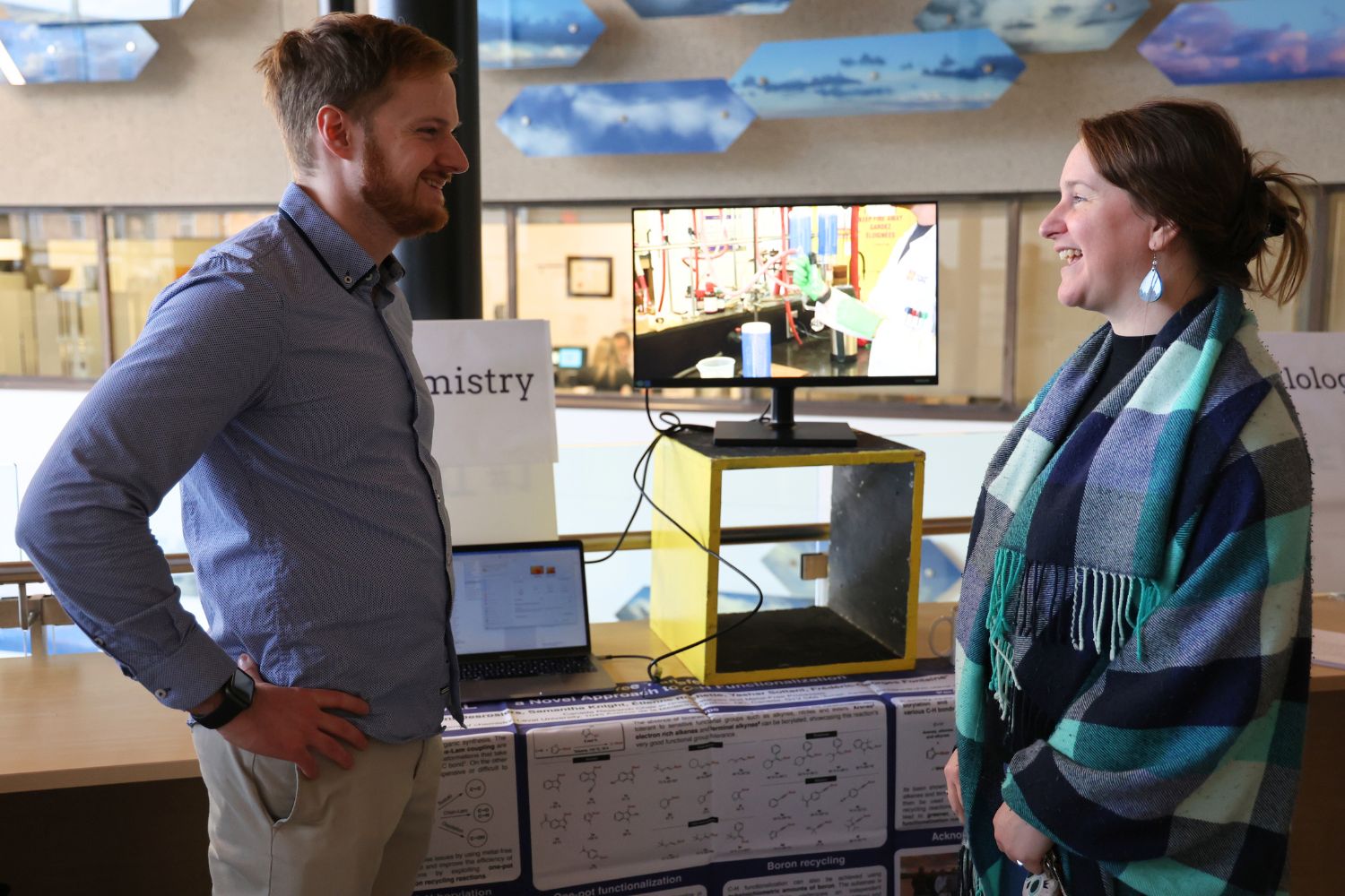 Vincent Desrosiers explains his chemistry research to an attendee.