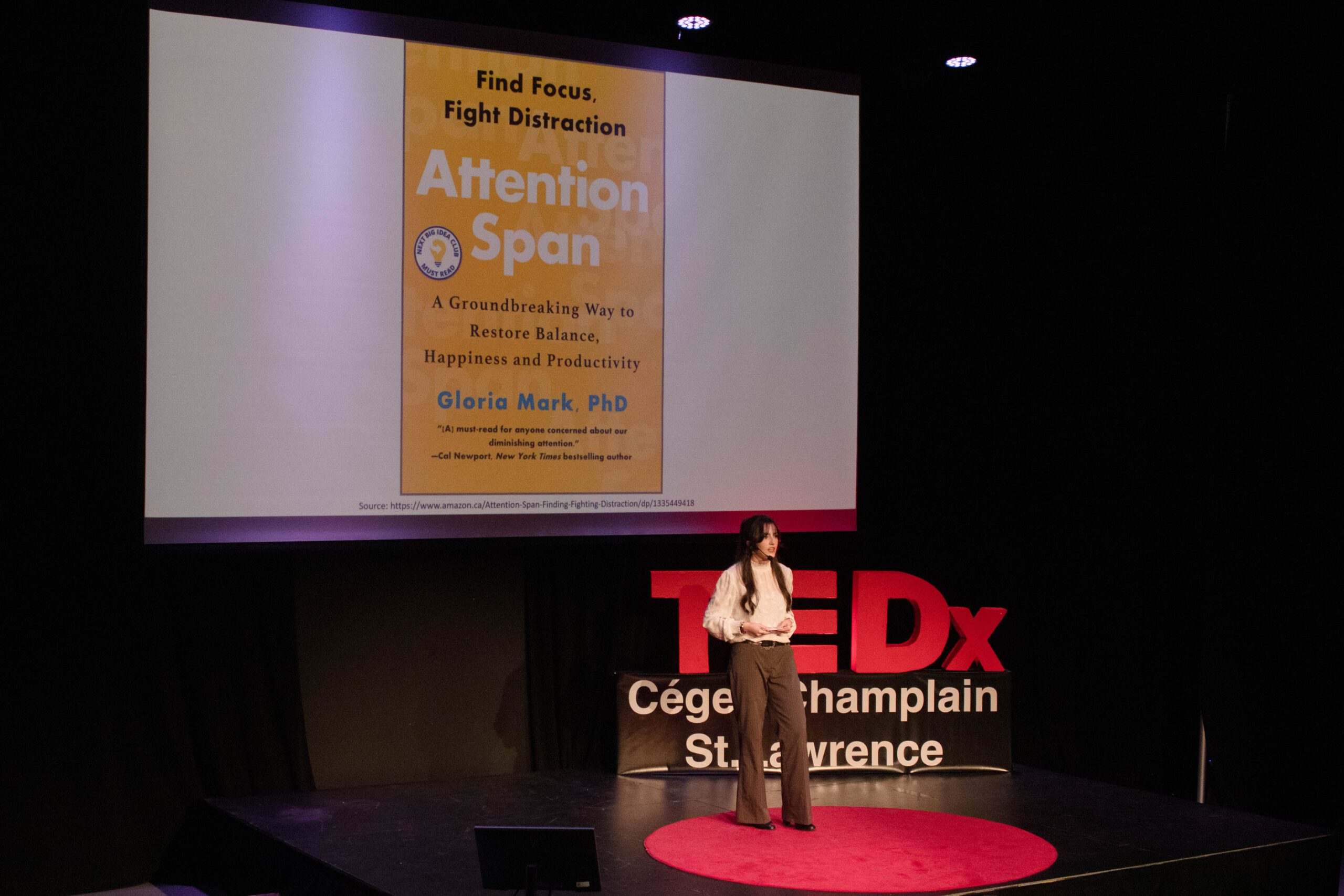 Student gives a talk in front of the TEDx sign