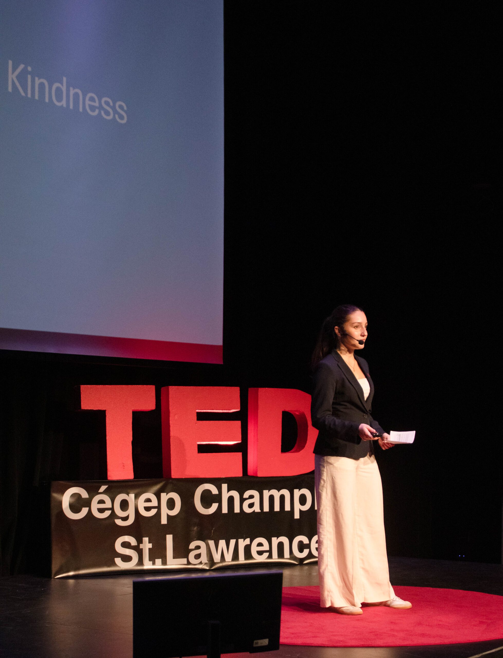 Student gives a talk in front of the TEDx sign