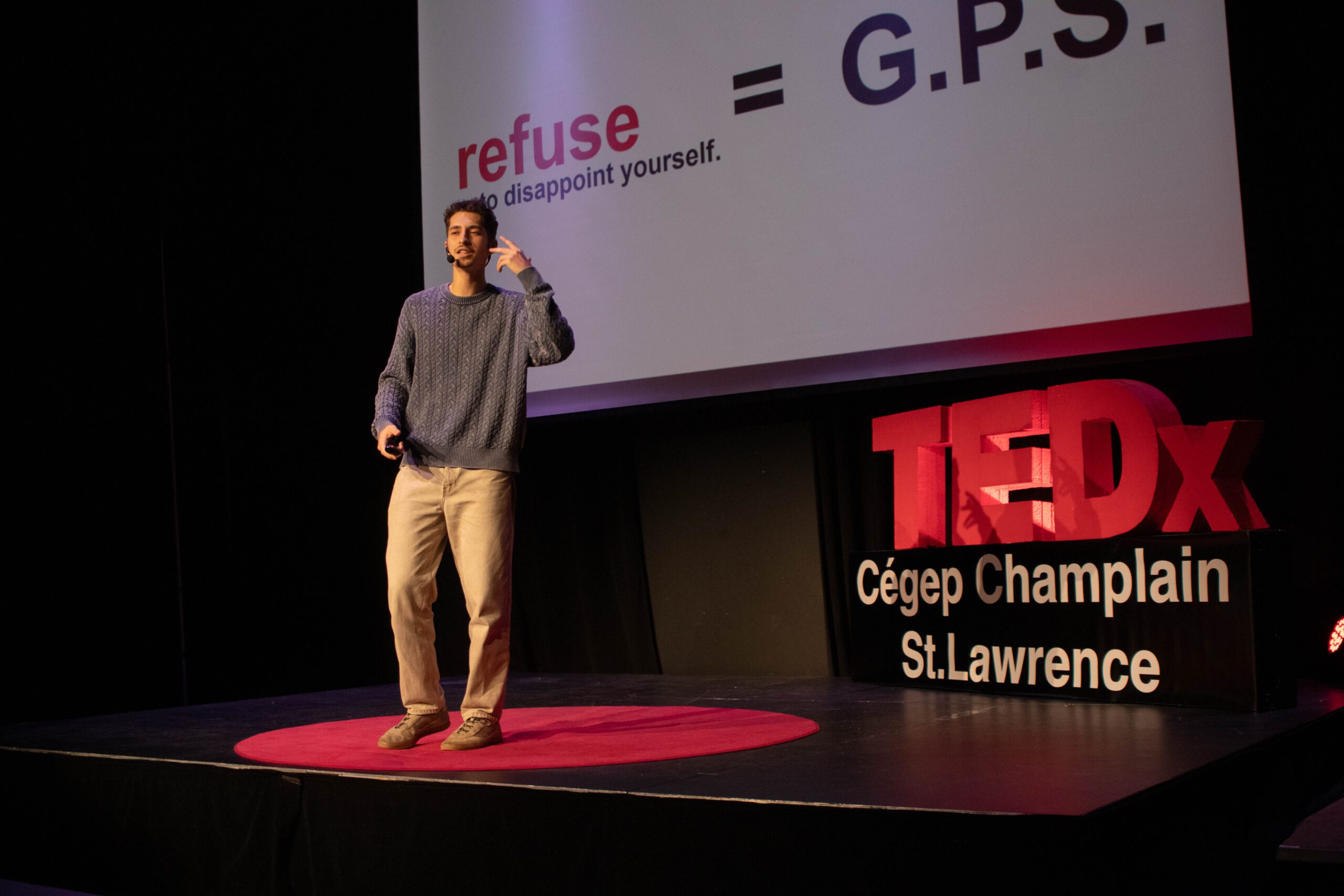 Student gives a talk in front of the TEDx sign