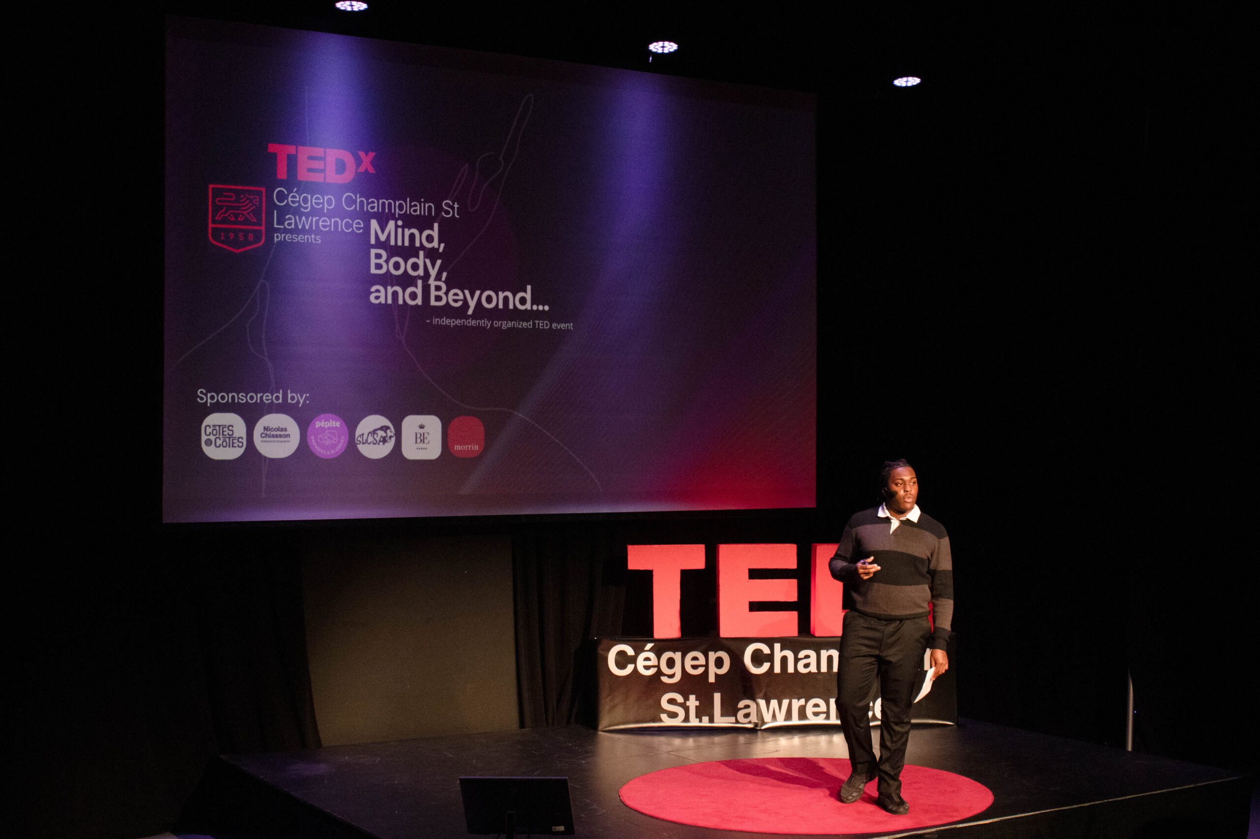 Student gives a talk in front of the TEDx sign